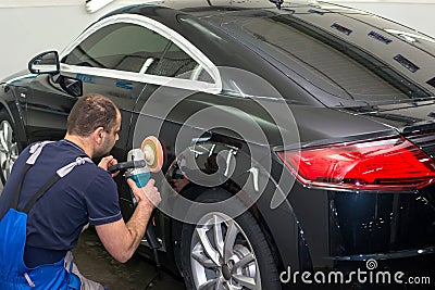 A man polishes a black car Stock Photo
