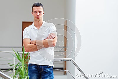 Man in a polo shirt stands leaning on railing Stock Photo