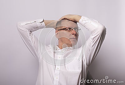 Man pondered and takes his head with hands and looking straight Stock Photo