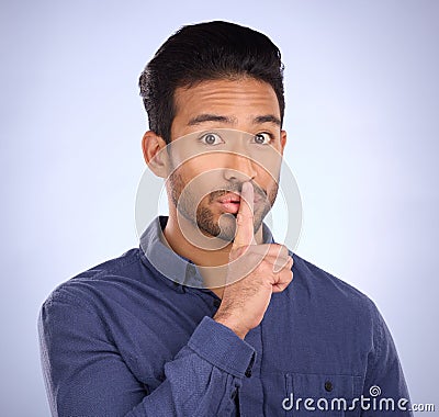 Man, portrait and finger on lips for secret, gossip or silence in studio with blue background. Face of a asian model Stock Photo