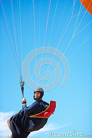 Man, portrait and paragliding in blue sky parachute for adventure fun, clouds or explore city. Male person, face and Stock Photo