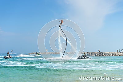 Man posing at new flyboard at Caribbean tropical beach. Positive Stock Photo