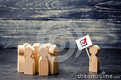 A man with a poster agitates a group of people. Voters, the political process. Political movement, faction, party. Agitation Stock Photo