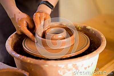 Man potter work with clay ware. Young man potter on his workshop with nature background Stock Photo