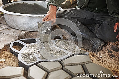 Man pour cement in to a Mold to Make Concrete PaversÂ  Stock Photo