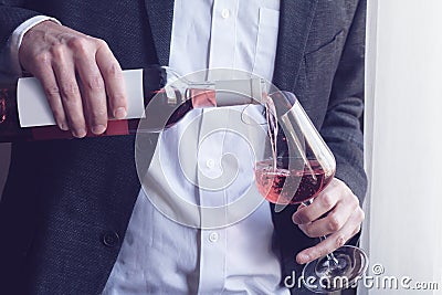 Man pouring rose wine into a glass Stock Photo