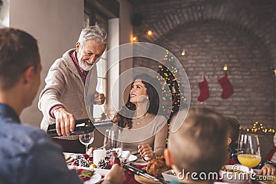Man pouring wine for family Christmas dinner Stock Photo