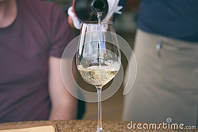 Man pouring wine into glass in a restaurant. Waiter serving drink. Wine tasting concepts Stock Photo