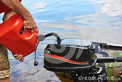 Man pours petrol into engine of fishing boat Stock Photo