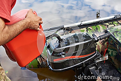 Man pours petrol into engine of fishing boat Stock Photo