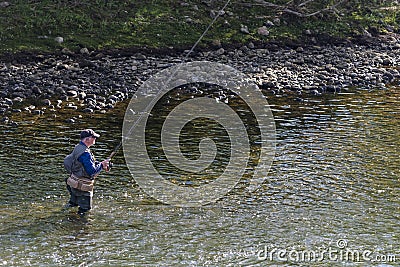 A man practices fishing inside the river Editorial Stock Photo