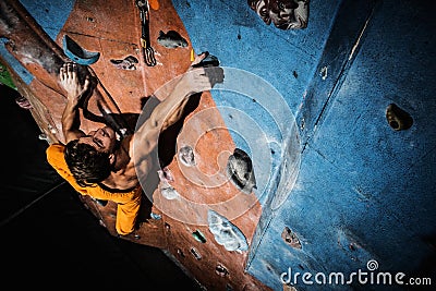 Man practicing rock-climbing on a rock wall Stock Photo