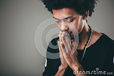 Man praying hands clasped hoping for best asking for forgiveness or miracle Stock Photo