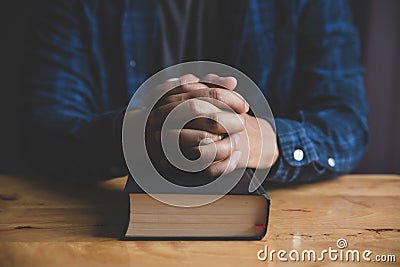 A Man praying holding a Holy Bible. Stock Photo