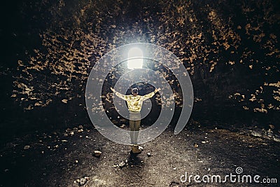 Man praying and hoping with arms raised up to the mystery light. Religion miracle concept Stock Photo