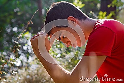 Man Praying in Nature Stock Photo