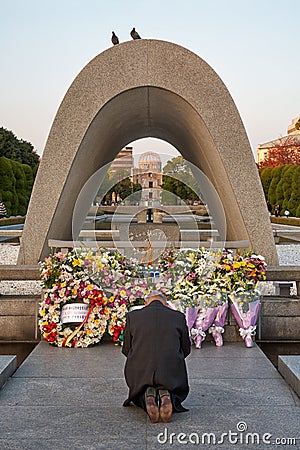 Man prays in front of the Memorial Cenotaph for the A-bomb Victims in Peace Park. Hiroshima. Japan Editorial Stock Photo