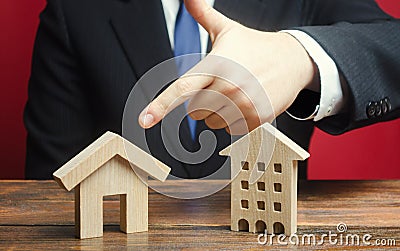 A man prefers to choose a private house rather than an apartment residential building. Definition for current needs, location. Stock Photo