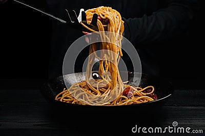 A man prepares pasta with spaghetti, tomatoes and spices Stock Photo