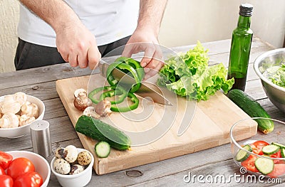 Man prepares a salad of fresh vegetables Stock Photo