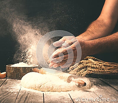 Man preparing bread dough on wooden table in a bakery Stock Photo