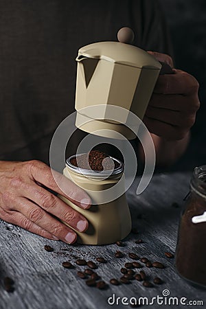 Man preparing coffee in a beige moka pot Stock Photo