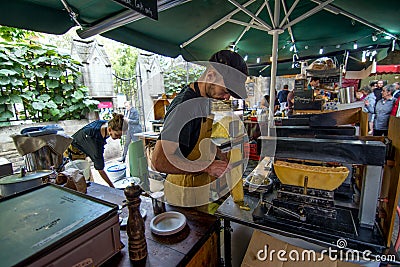 Man preparing french fries with melted cheese in one of the London`s borrow market Editorial Stock Photo