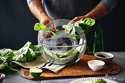 Man preparing green salad romaine lettuce healthy food Stock Photo