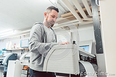 Man preparing large format printer for a print job Stock Photo