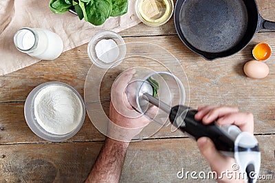 Man preparing spinach pancakes wooden table top view Stock Photo