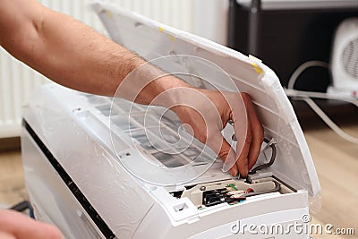 Man preparing to install new air conditioner. Modern air conditioner during the installation process Stock Photo