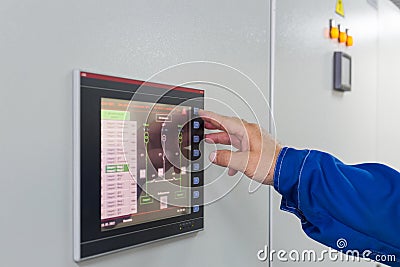 A man presses a button on color screen control Stock Photo