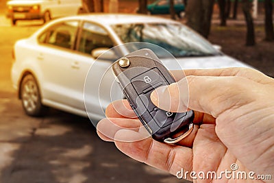 Man presses button on ignition key with immobilizer on the background of the car Stock Photo