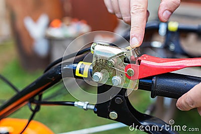 A man presses the handle of the safe shutdown of a walk-behind tractor with his hand during work. Copy space for text Stock Photo