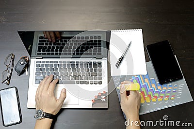 A man prints on a laptop, lying next to the phone, tablet glasse Stock Photo