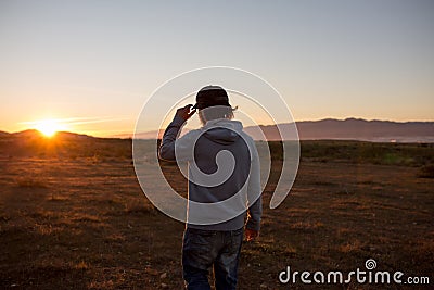 Man in a pristine landscape during a beautiful blazing sunset Stock Photo