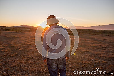 Man in a pristine landscape during a beautiful blazing sunset Stock Photo