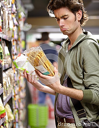 Man, product and comparison choice in supermarket for label difference, nutrition value or grocery shopping. Male person Stock Photo