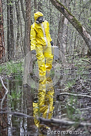 Man in professional uniform walking in contaminated floods area Stock Photo