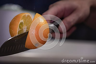 A man professionally cuts a orange Stock Photo