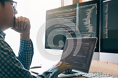 Man programmers are stressed and hand holding nose with headache at the office while working analyzing on desk in code at office Stock Photo