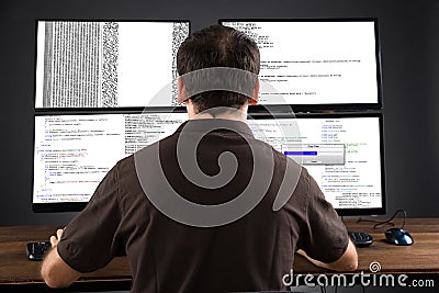 Man Programming Code On Computers Stock Photo