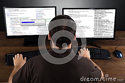 Man Programming Code On Computers Stock Photo