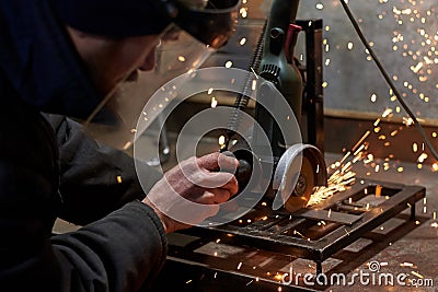 A man in a protective mask cuts metal on a machine tool Stock Photo