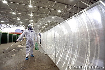 Man in protective suit is spraying, disinfection and decontamination on a public place as a prevention against Coronavirus 2019 Editorial Stock Photo