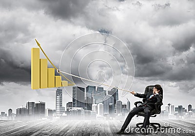 Man pulling with effort big pulling rope graph, as a symbol of financial growth Stock Photo