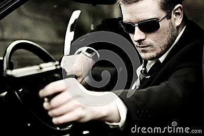 Man pulls a gun in car Stock Photo