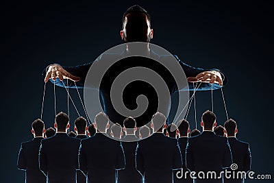 A man, a puppeteer, controls the crowd with threads. The concept of world conspiracy, world government, manipulation, world Stock Photo