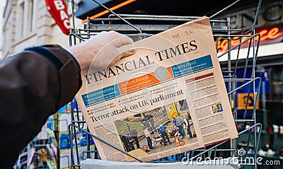 Man purchases Financial times newspaper from press kiosk after L Editorial Stock Photo