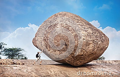 Man pushing a big stone Stock Photo